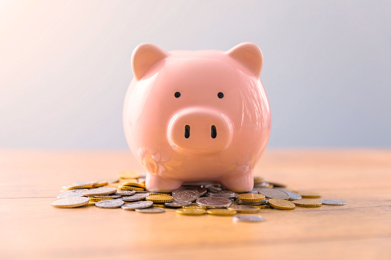 An image of a piggy bank sitting on coins