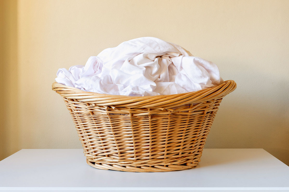 An image of white sheets in a wicker basket