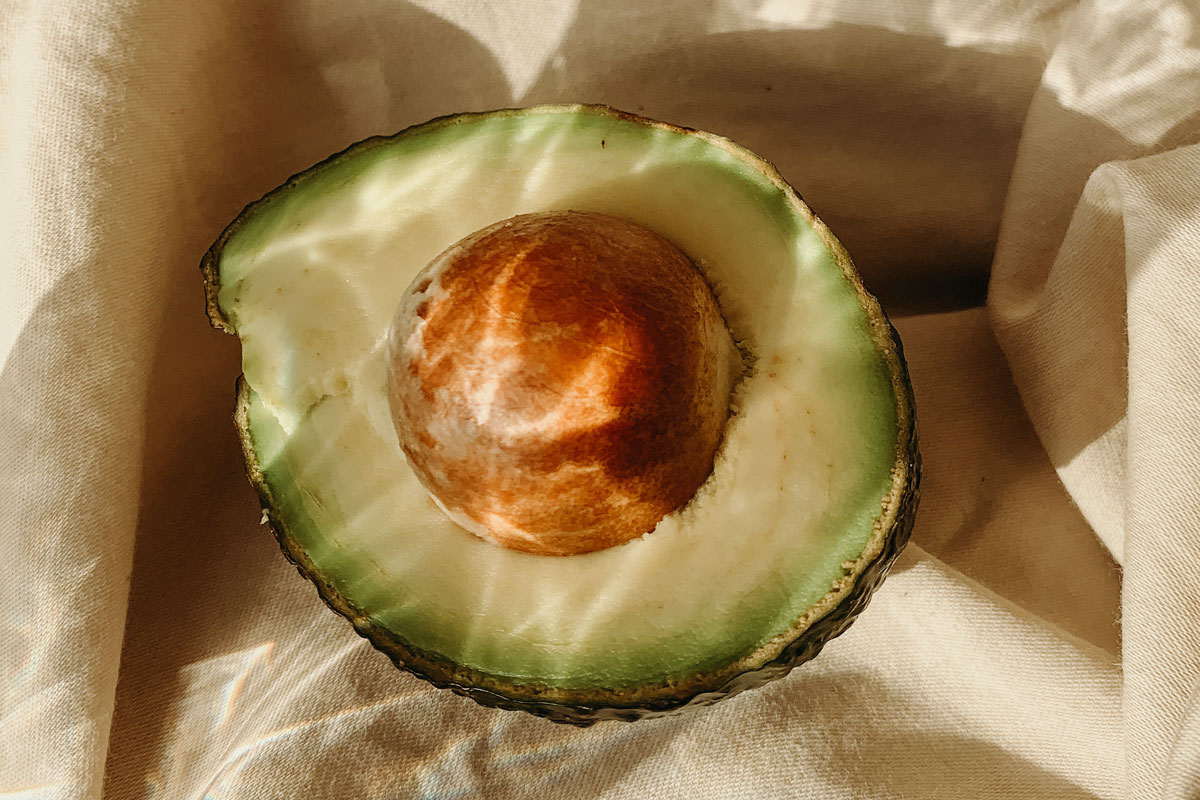 An image of a half of an avocado with the pit