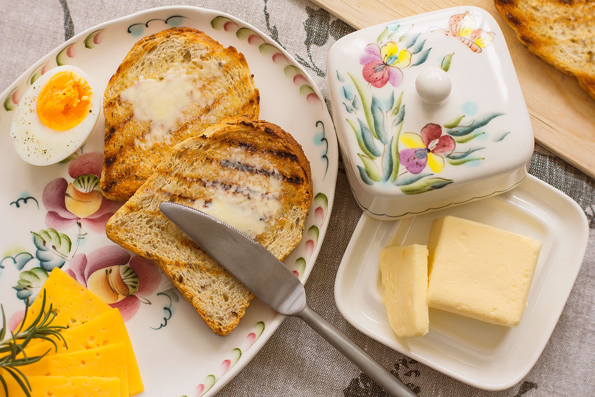 An image of a breakfast plate with toast, eggs, and butter