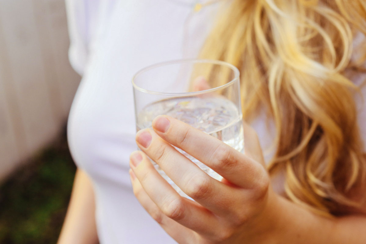An image of a woman holding a glass of water