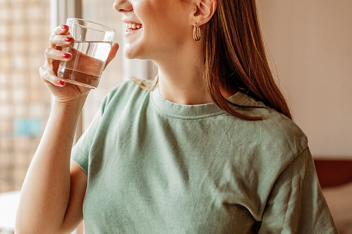 An image of a woman holding a glass of water