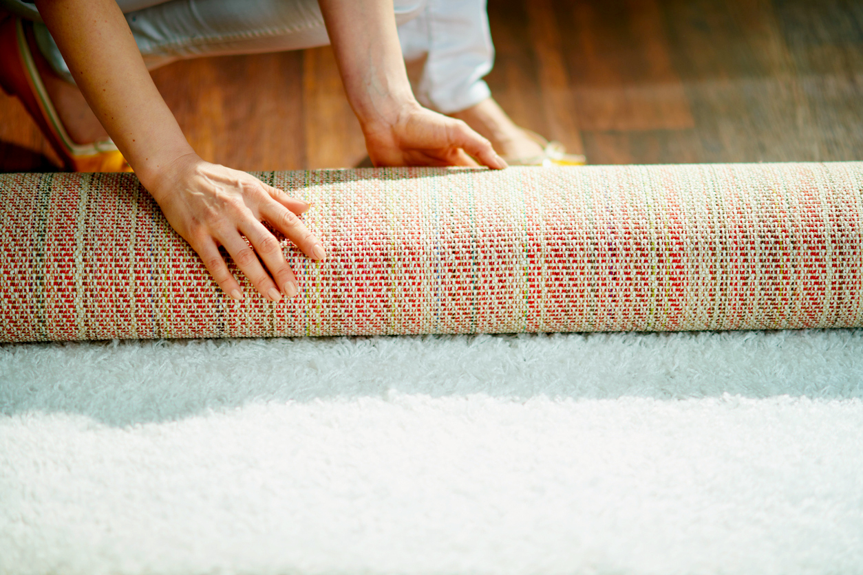 An image of a person unrolling a rug