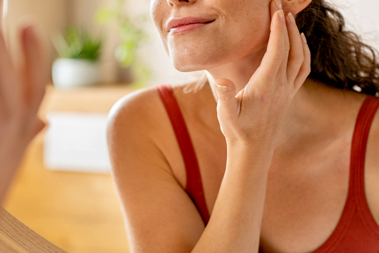 An image of a woman with her hand on her jaw