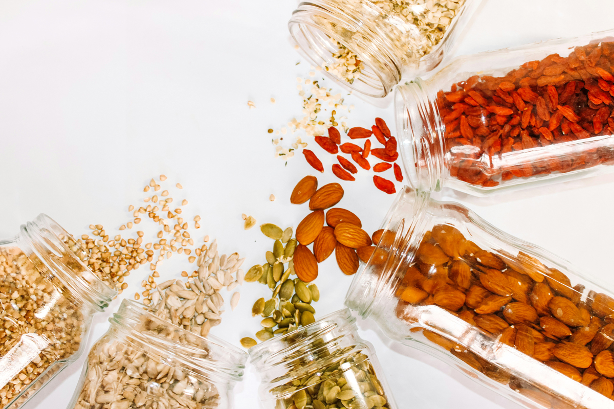 An image of jars of nuts an seeds spilling out