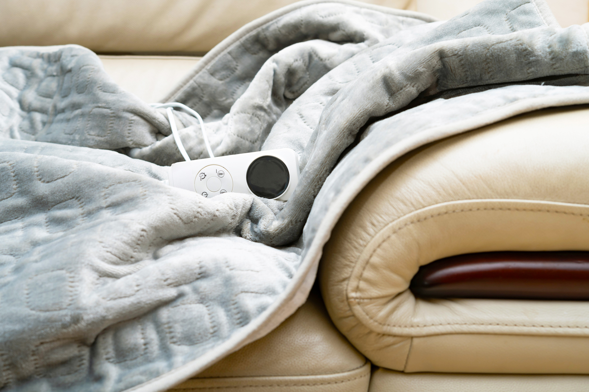 Electric blanket with controller on a sofa