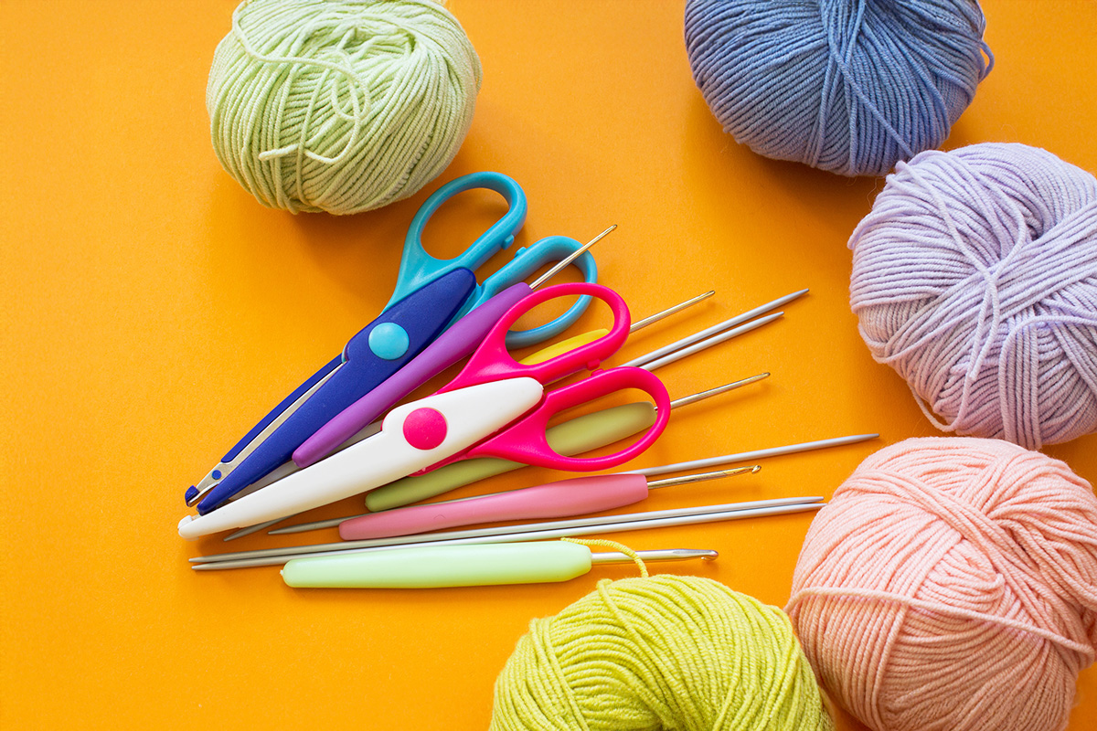 Crochet materials lying on orange background