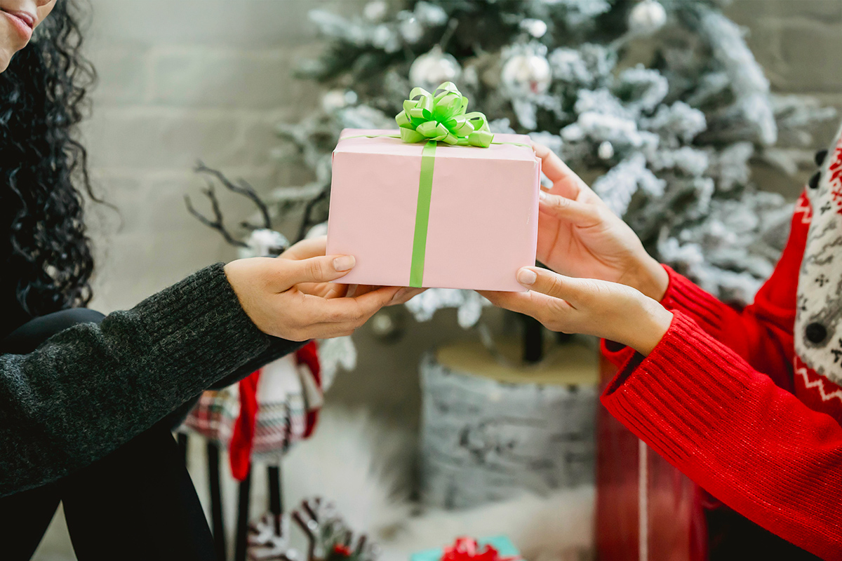 Woman giving gift box to a friend for the holiday