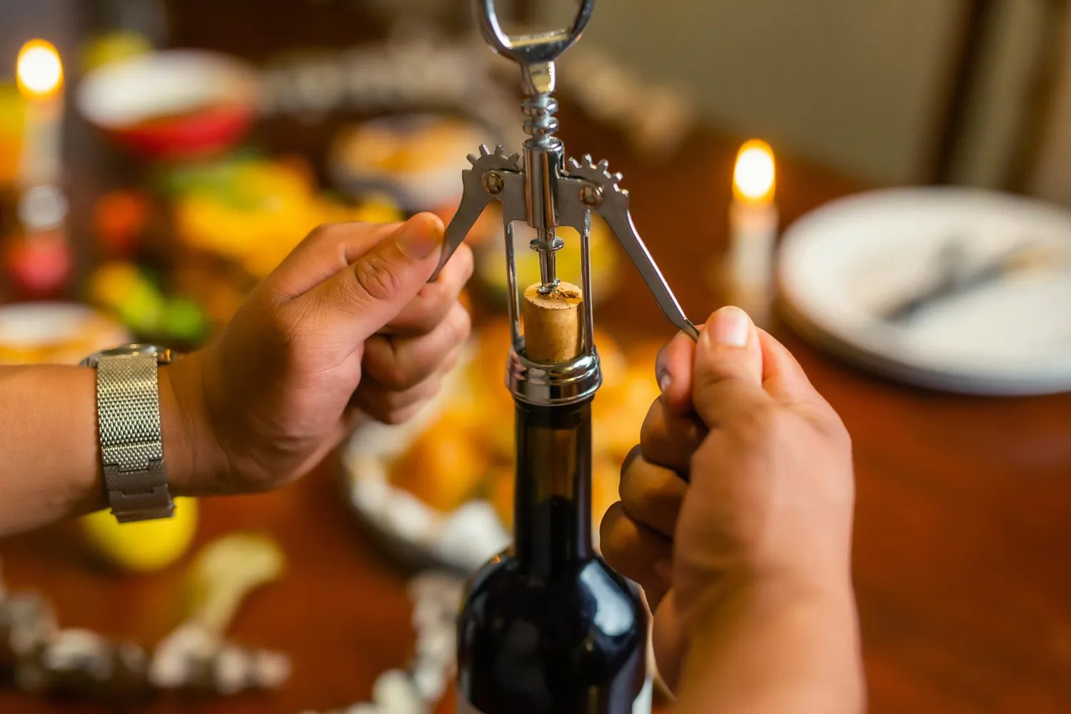Person opening a bottle of wine
