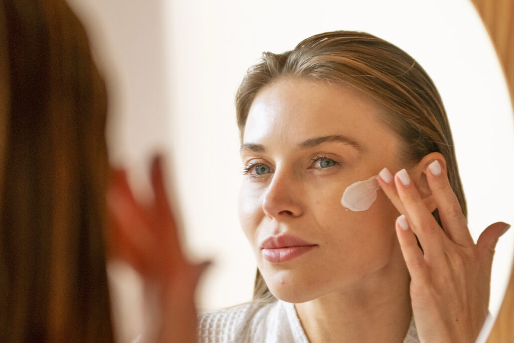 Woman putting on moisturizer