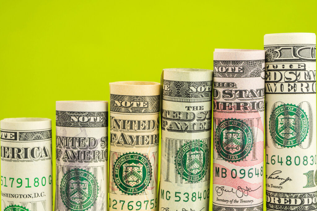 Rolled up money in front of a green background