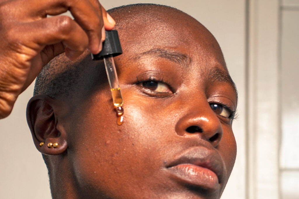 Woman using dropper to apply antioxidants