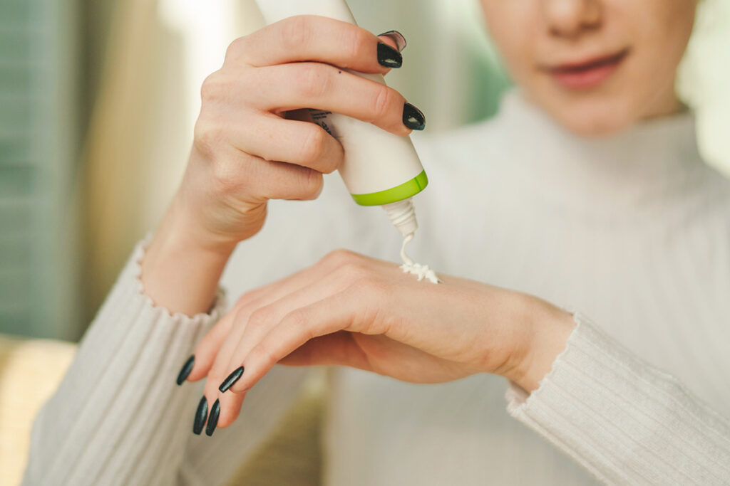 Woman putting sunscreen on hand