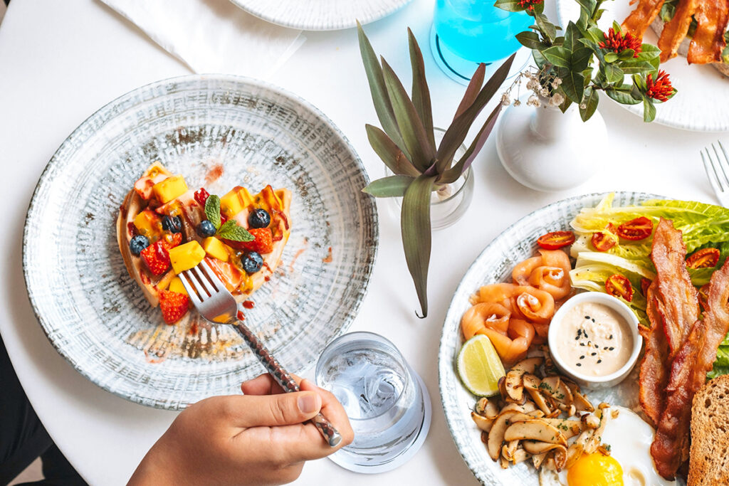 Person holding a fork eating a meal