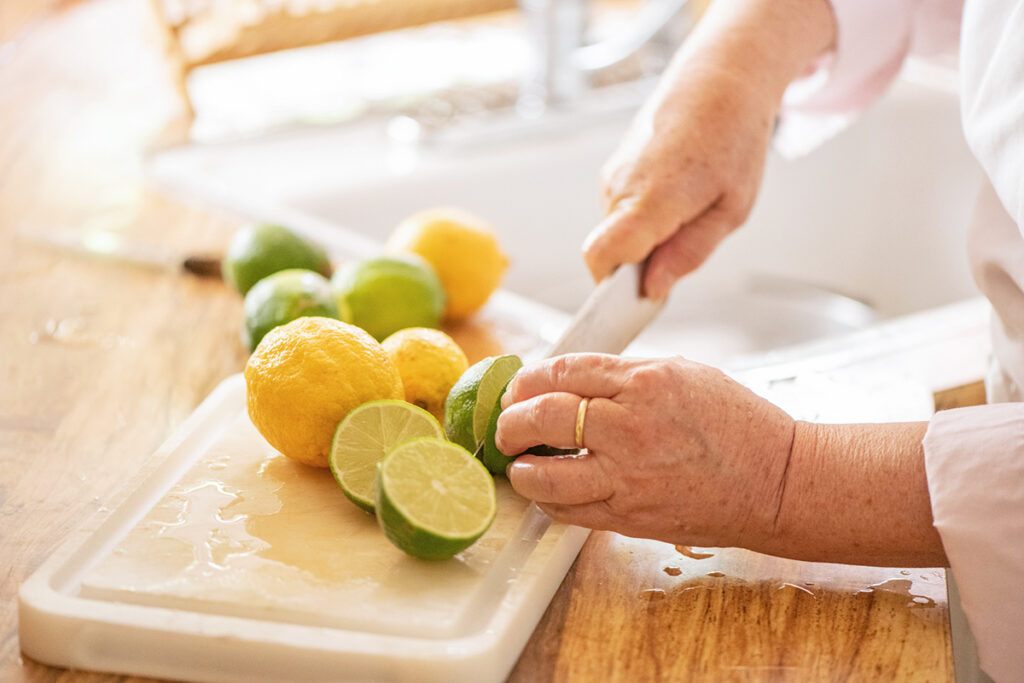 Person cutting limes and lemons