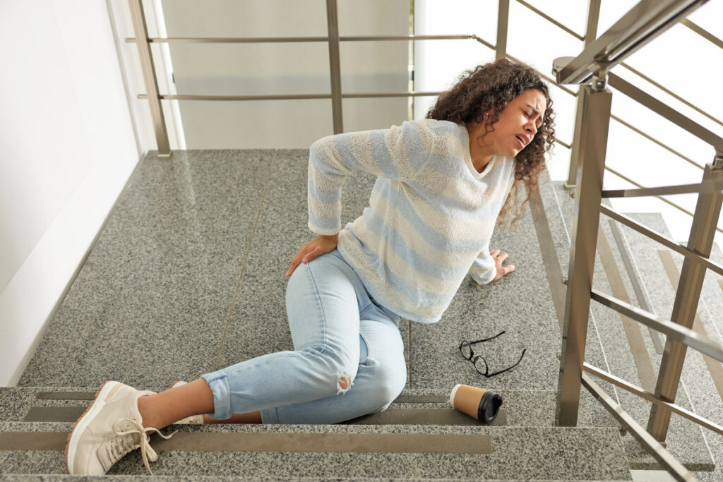 Woman who fell down the stairs holding her back