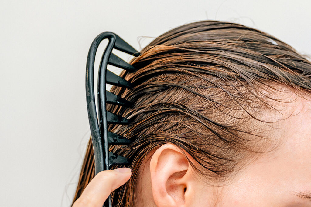 Person running comb through wet hair