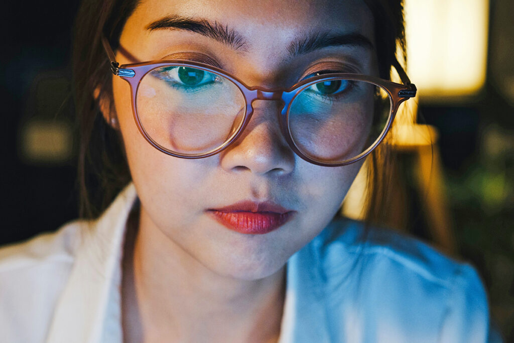 Woman wearing glasses staring at screen