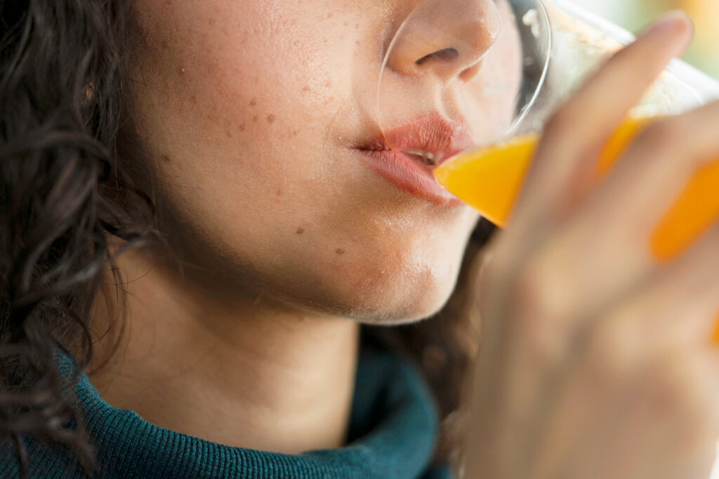 Person drinking orange juice