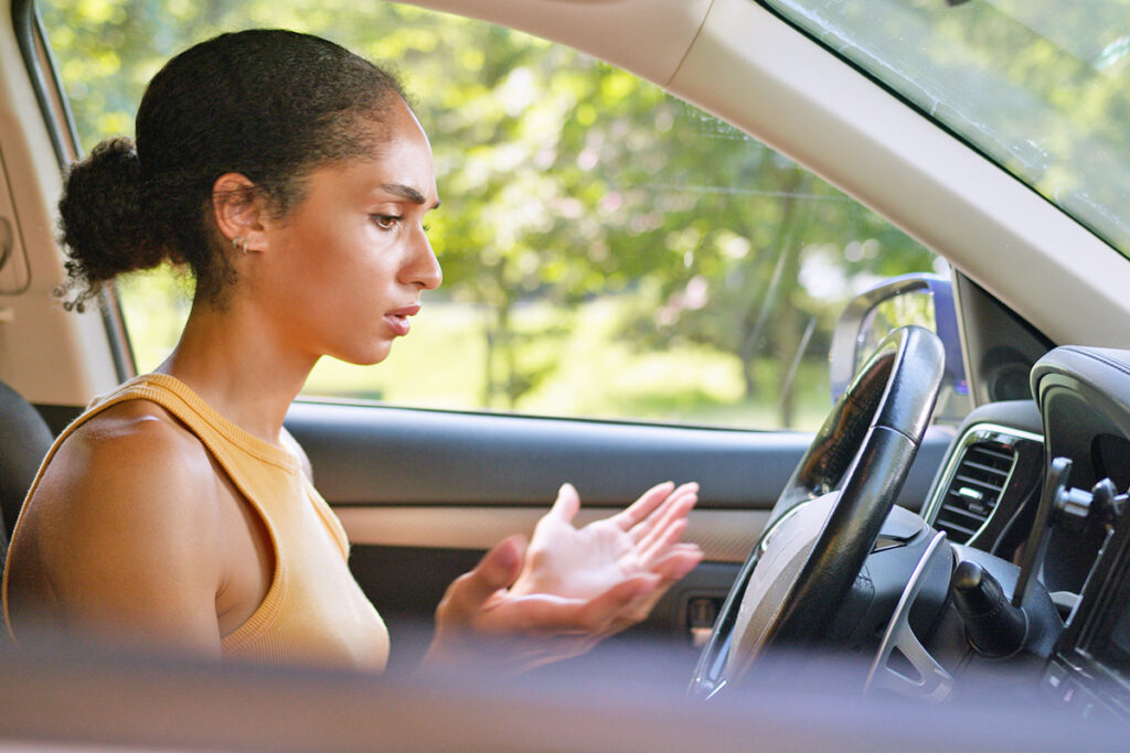 Person in car staring at steering wheel