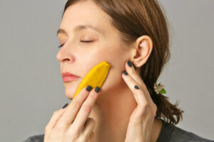 Woman running banana peel on face