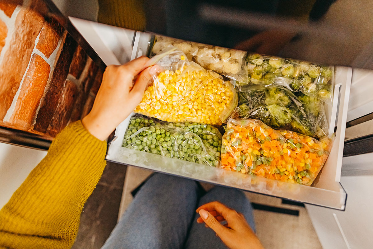 Person putting vegetables in the freezer
