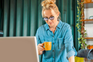 Woman looking at computer wearing blue light glasses