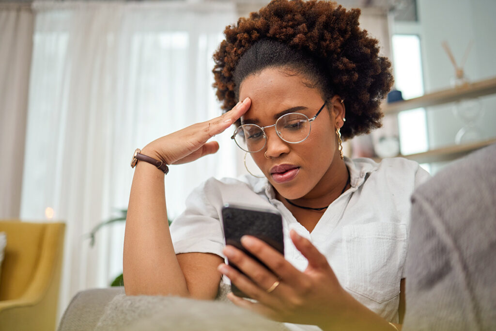Woman looking down at phone upset