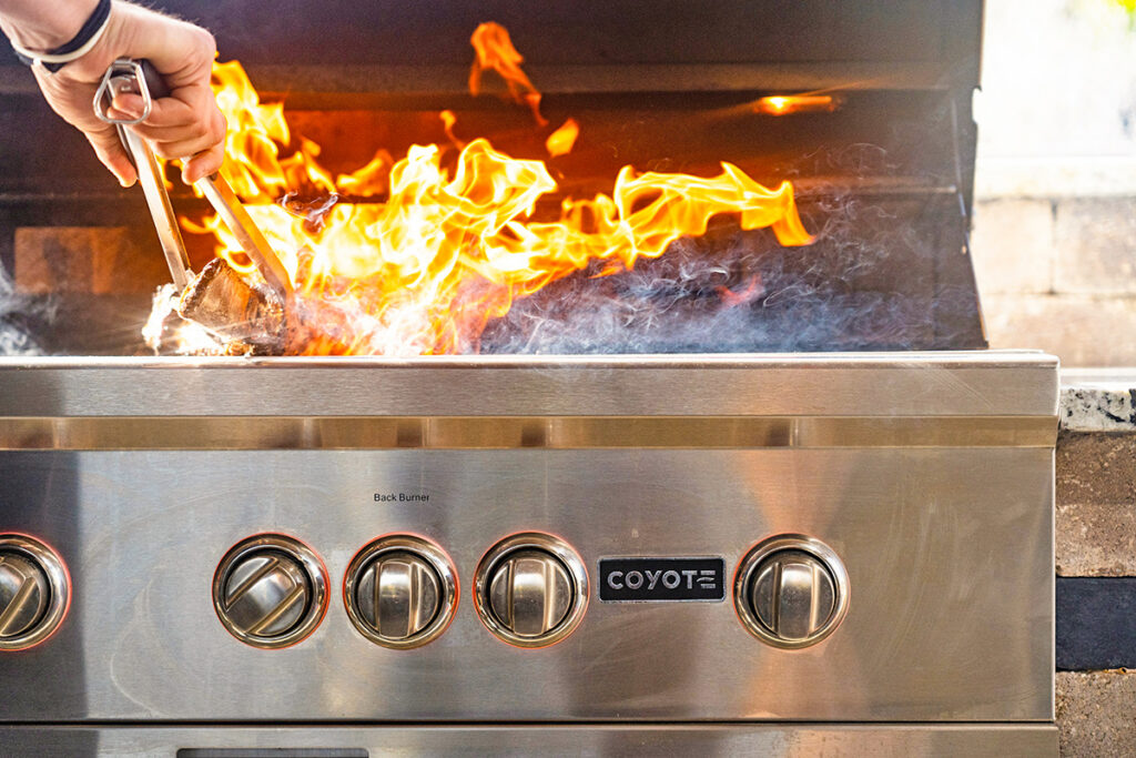 Person cooking on grill with fire