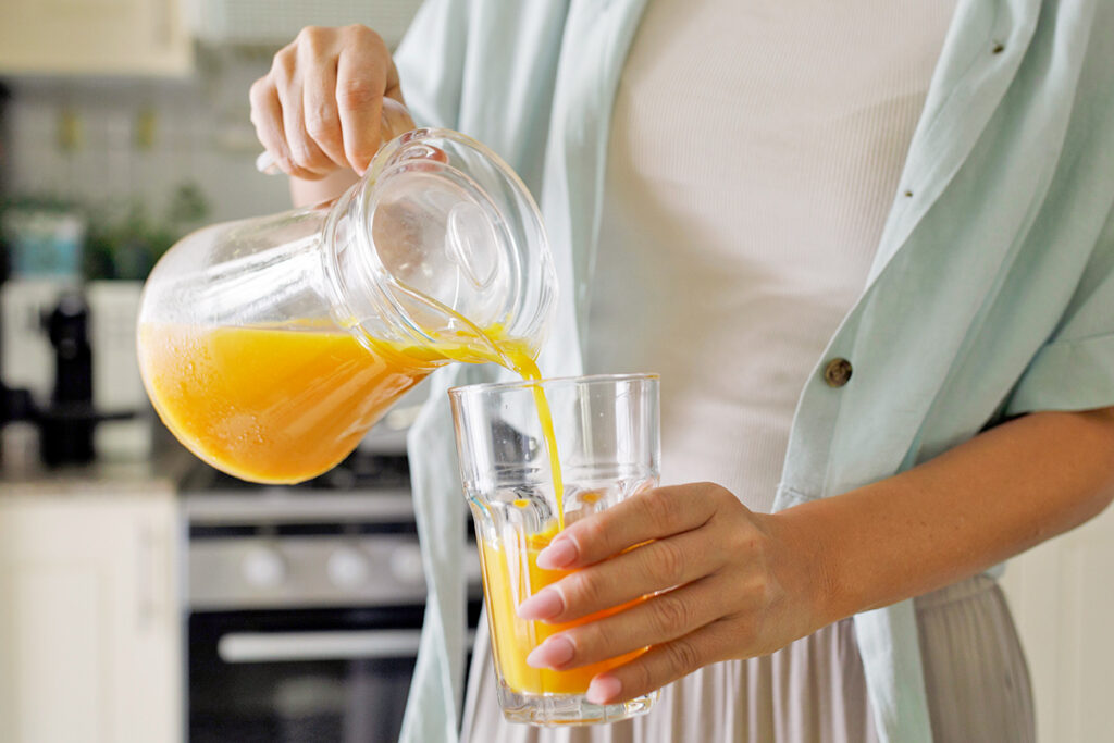 Woman pouring orange juice
